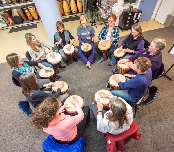 Bettie Seitzer (far right) leads a Tuesday night drumming circle in the basement of the Dow Building on University Avenue. Photo by Mike Krivit