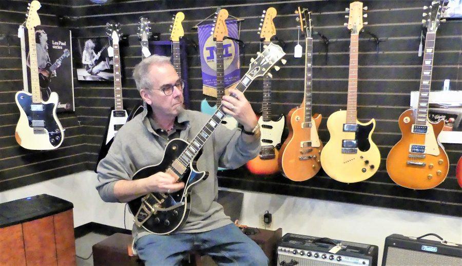 Nate Westgor is owner of Willie’s American Guitars. The store is relocating this spring to St. Anthony Park.
Westgor is holding a replica of a Gibson guitar owned by Led Zeppelin’s Jimmy Page. Photo by Cigale Ahlquist.