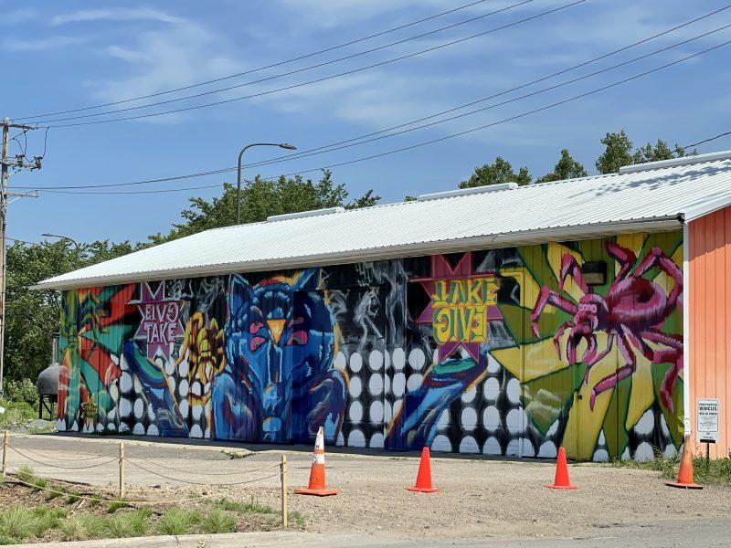 FOCUS Smith’s completed BANG It! mural, painted during the Chroma Zone kick off celebration in May 2021, between Bang Brewing Company and Urban Growler Brewing Co.