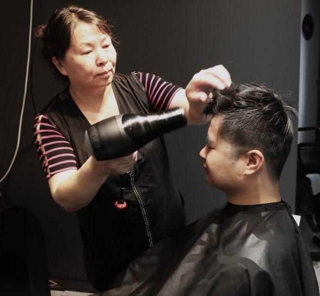 Ling Yu, owner of Salon Ling, gives a haircut to Alex Zhang. Photo by
Lou Michaels.